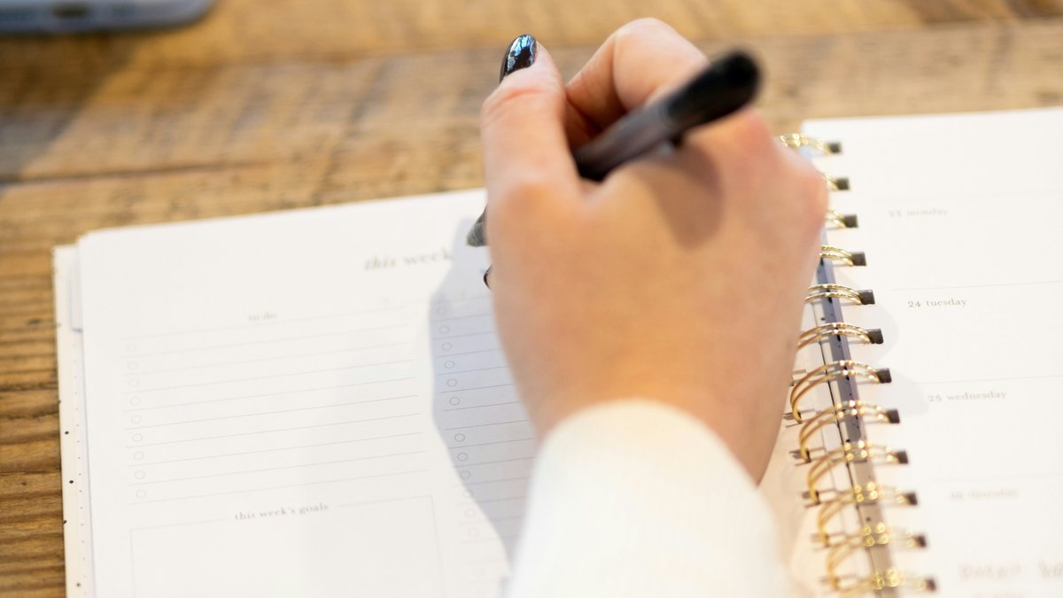 Open planner and pen on a wooden desk