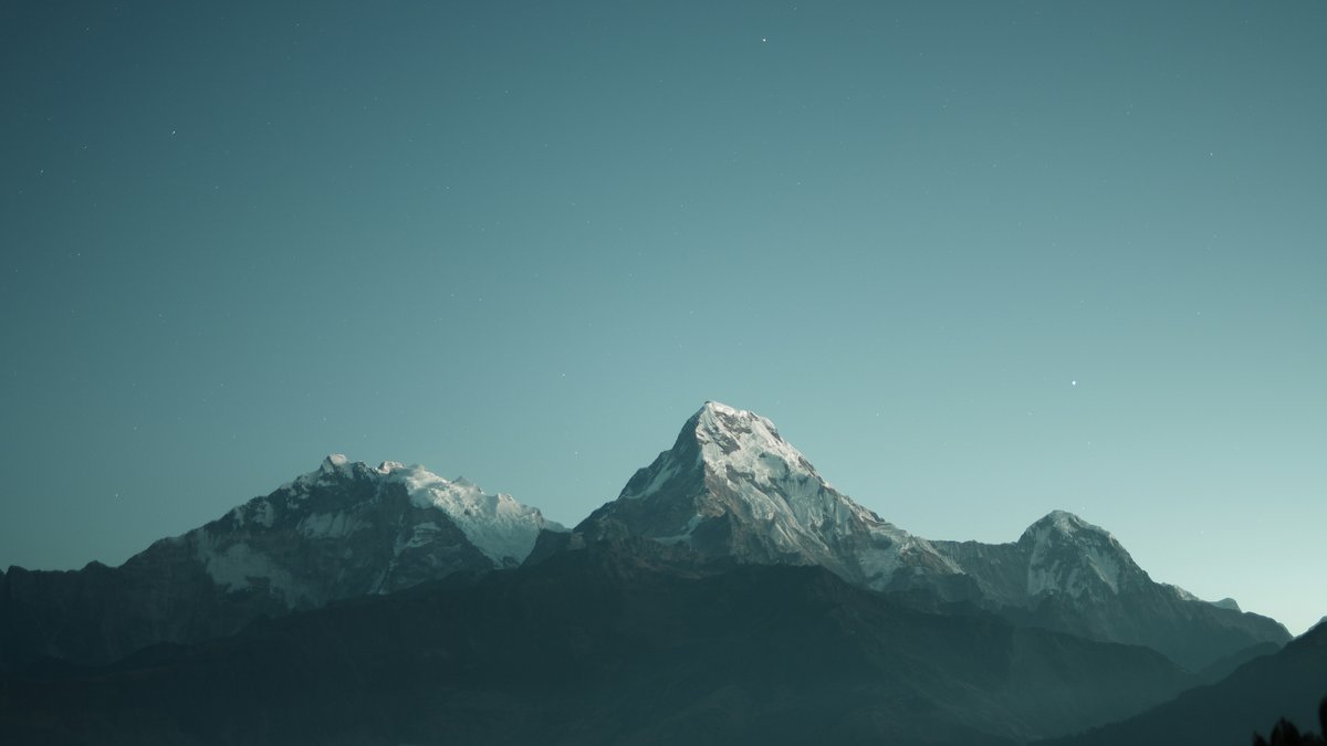 Snow-capped mountains under a starry night sky