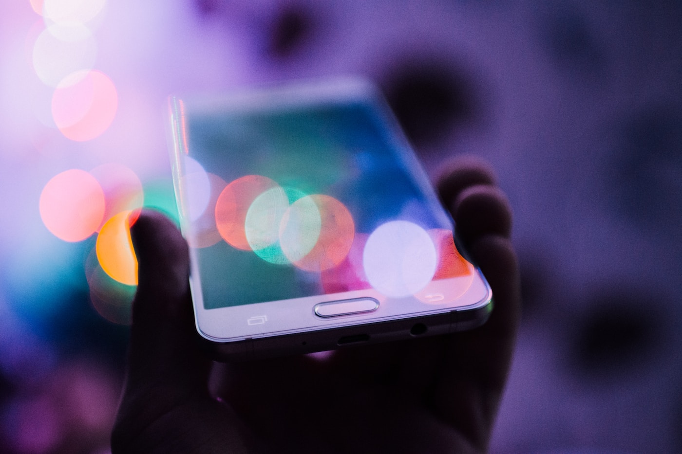 Hand holding a smartphone with a soft blurred background