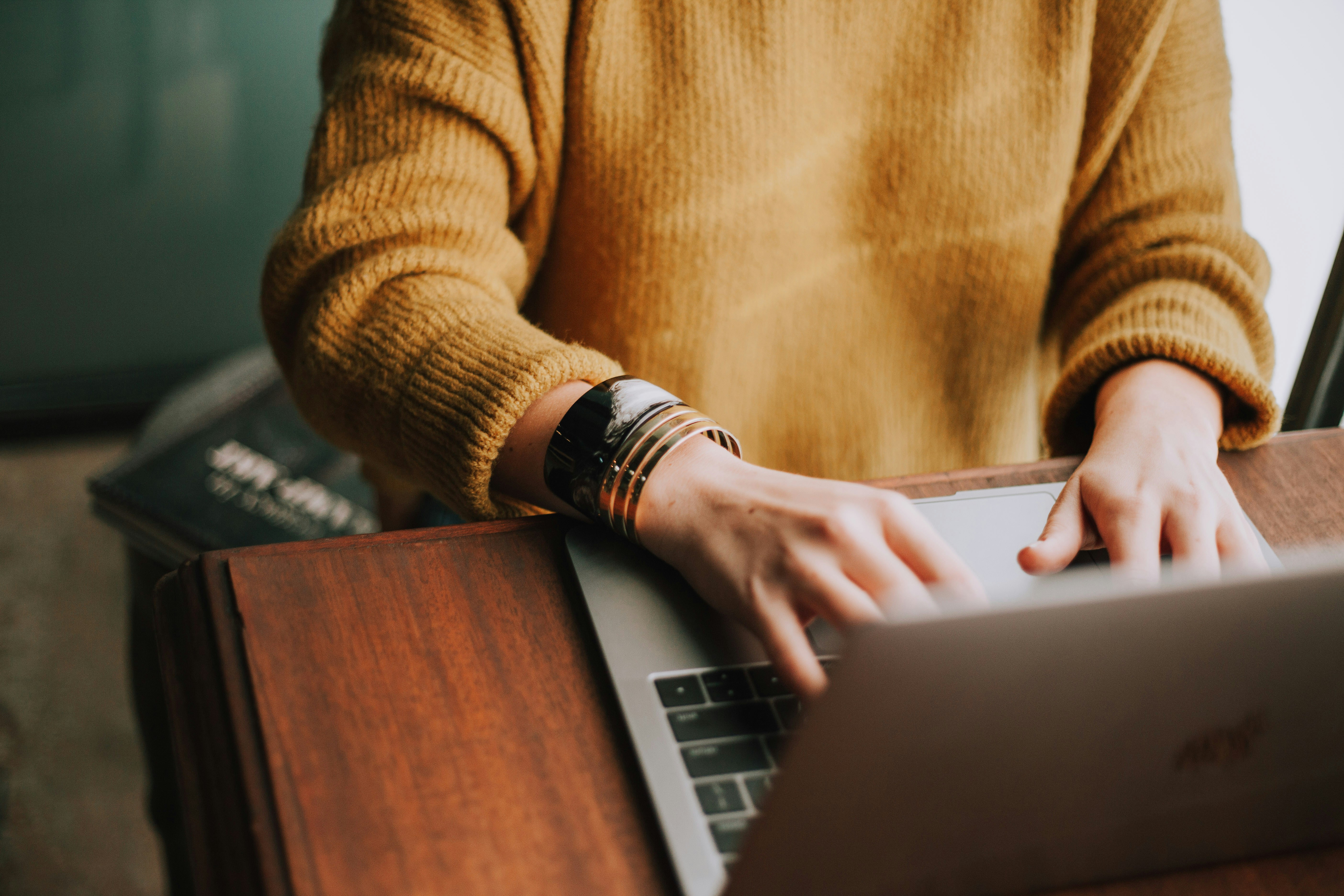 Person using a laptop at a desk in soft light
