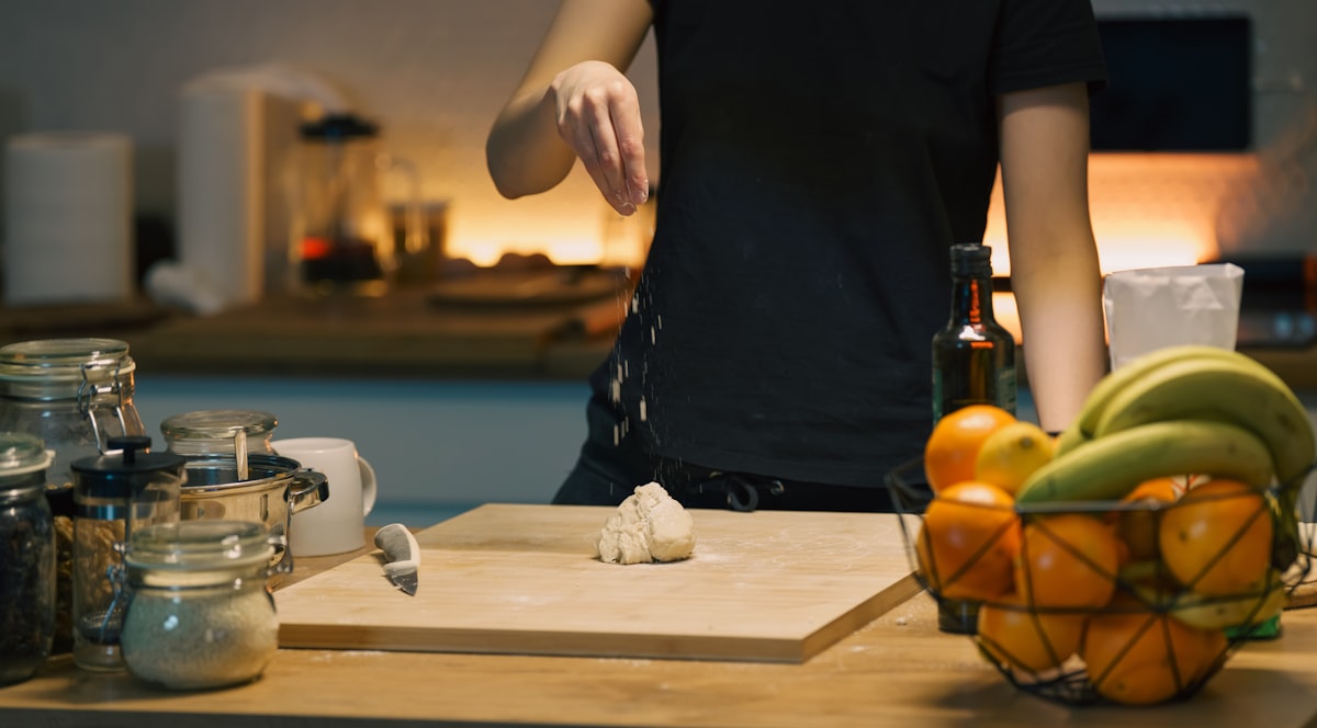 Hands preparing dough on a wooden kitchen board