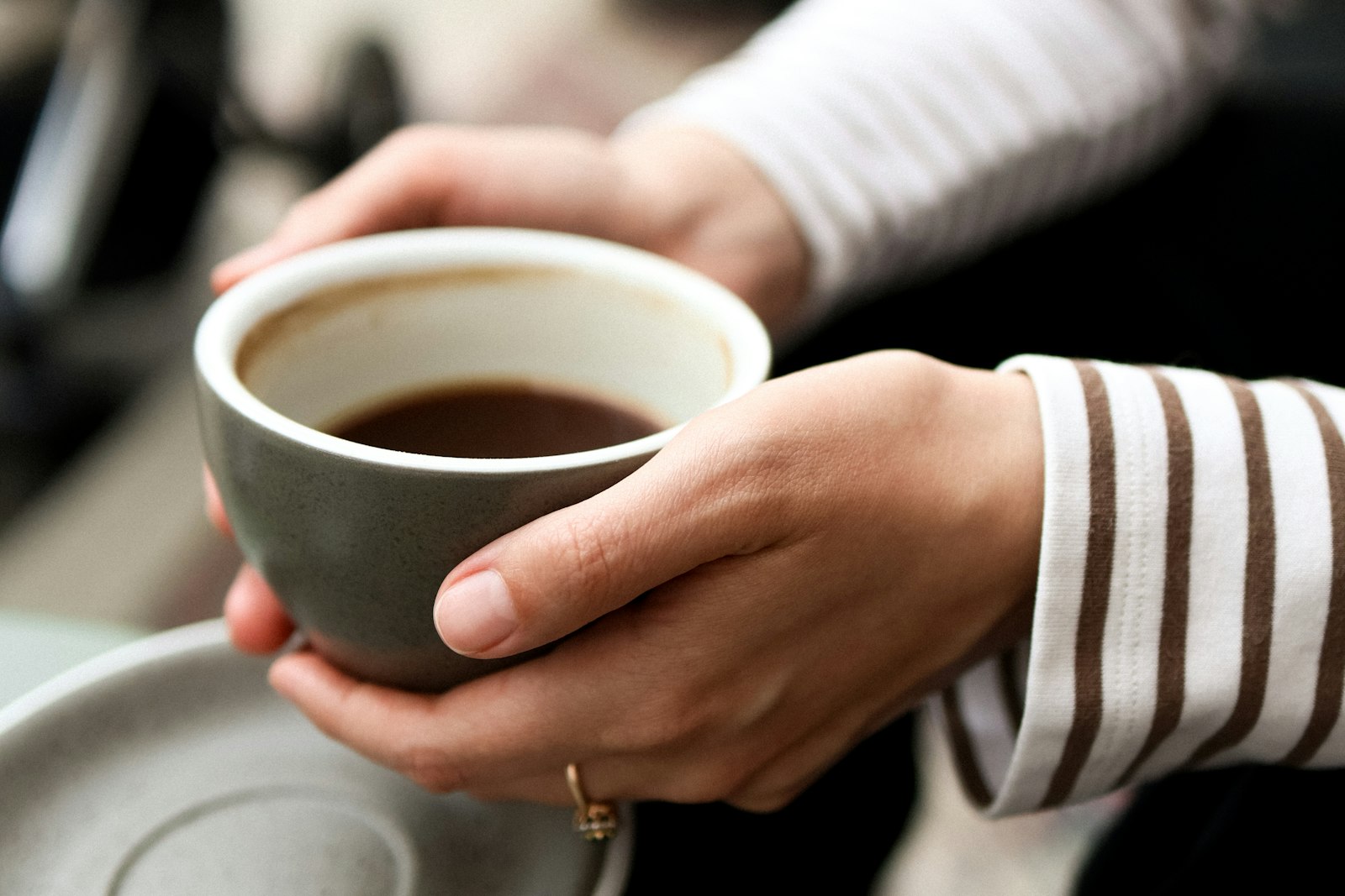 Hands holding a warm mug of coffee