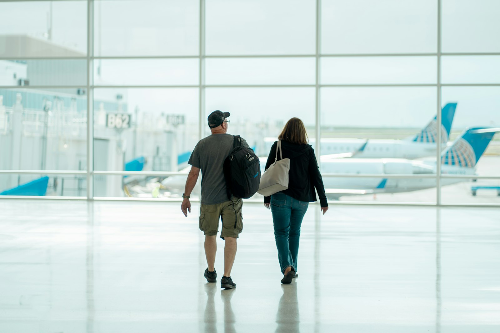 A man and a woman walking together through an airport
