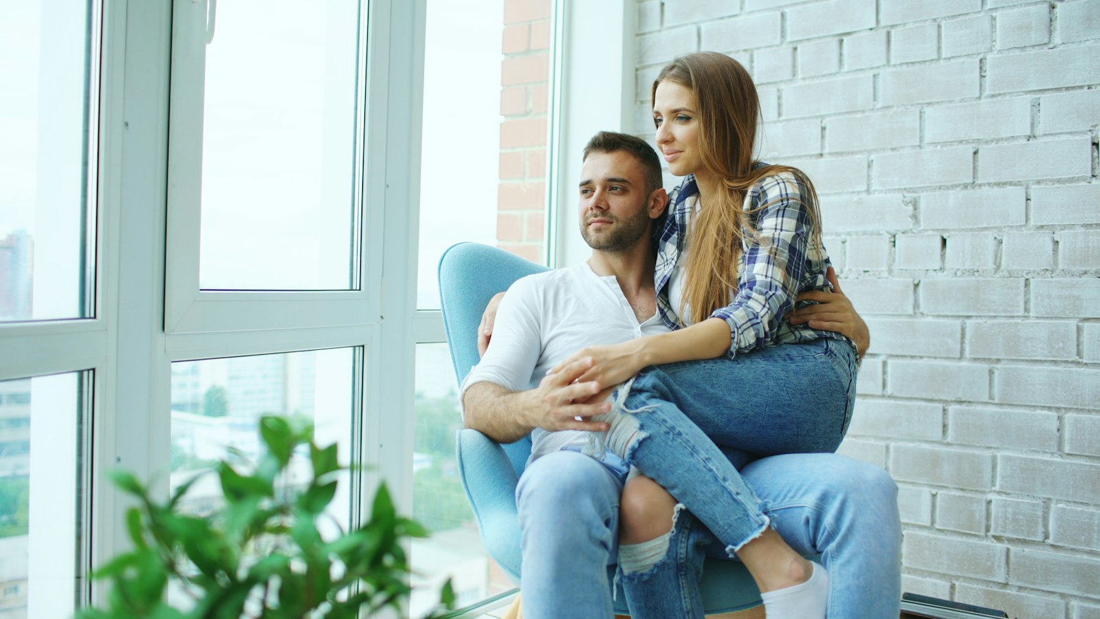 Couple sitting together by a window, relaxed and present with each other