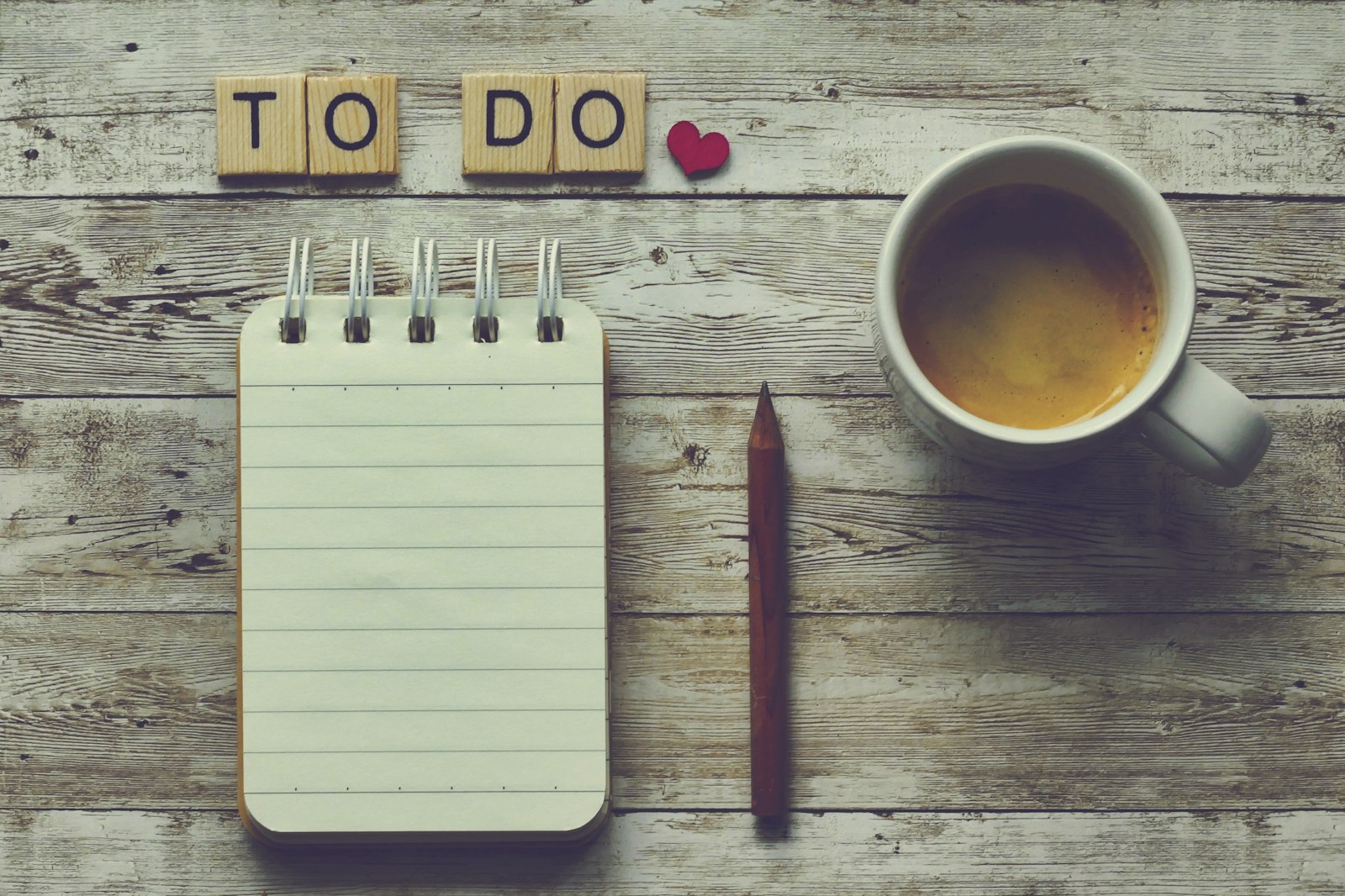 A notepad with a to-do list next to a cup of coffee