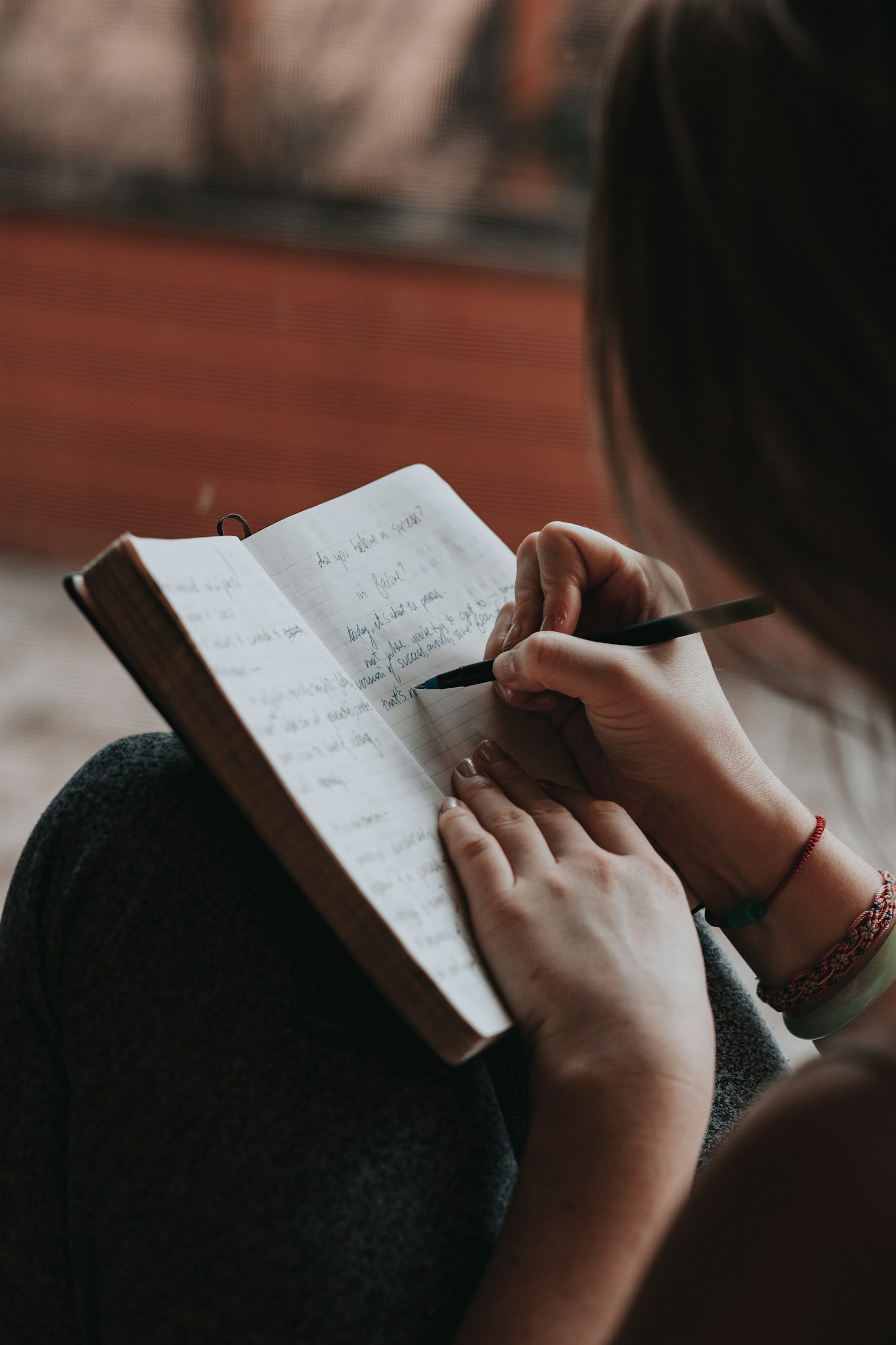 Woman writing in a notebook with a pen